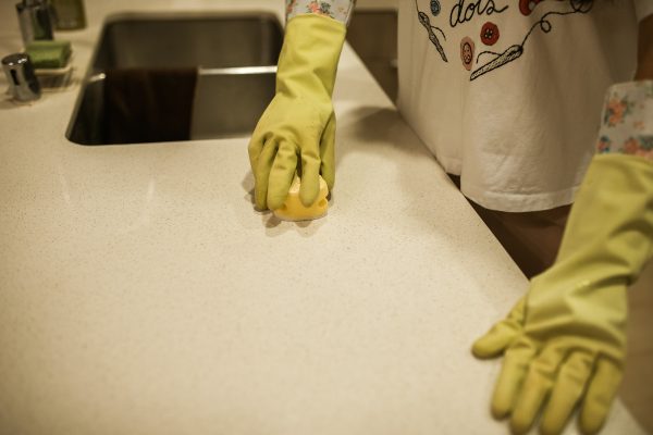 mains avec gants jaunes qui frotte avec une éponge