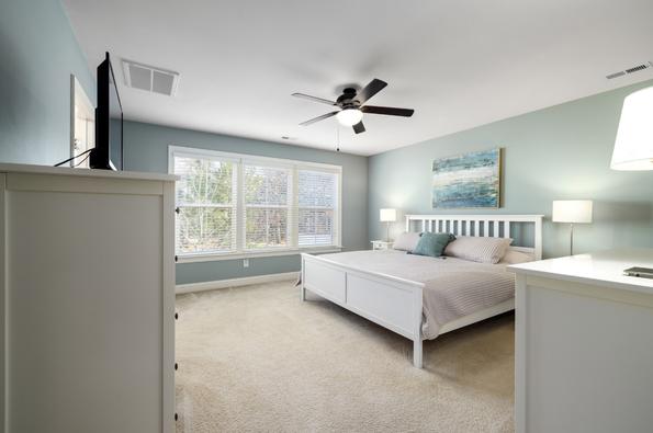 chambre propre avec un lit, un ventilateur et une armoire