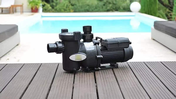 Pompe piscine posée devant une piscine