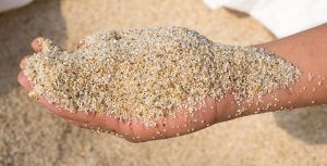 Main pleine de sable pour filtre piscine