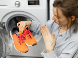 femme qui sort une paire de chaussure de la machine à laver