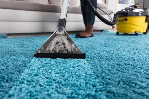 femme qui nettoie un tapis de salon avec un aspirateur laveur