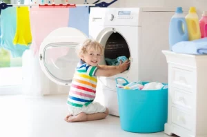 enfant qui mets du linge dans la machine à laver