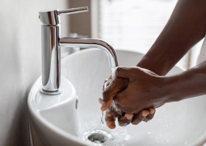 personne qui se lave les mains dans un lavabo
