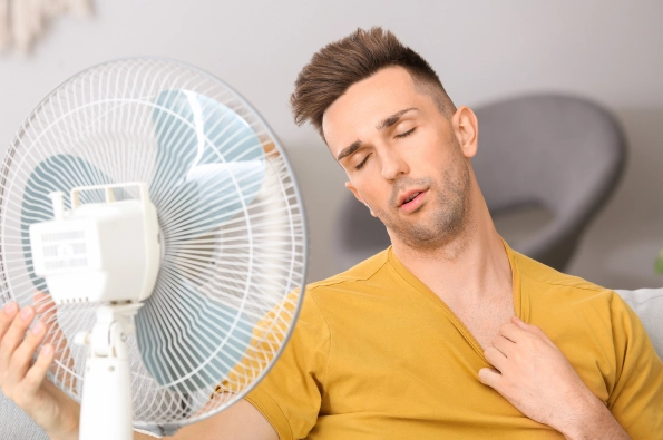 homme qui a chaud avec un ventilateur