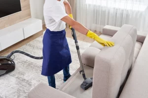 femme qui aspire un canapé